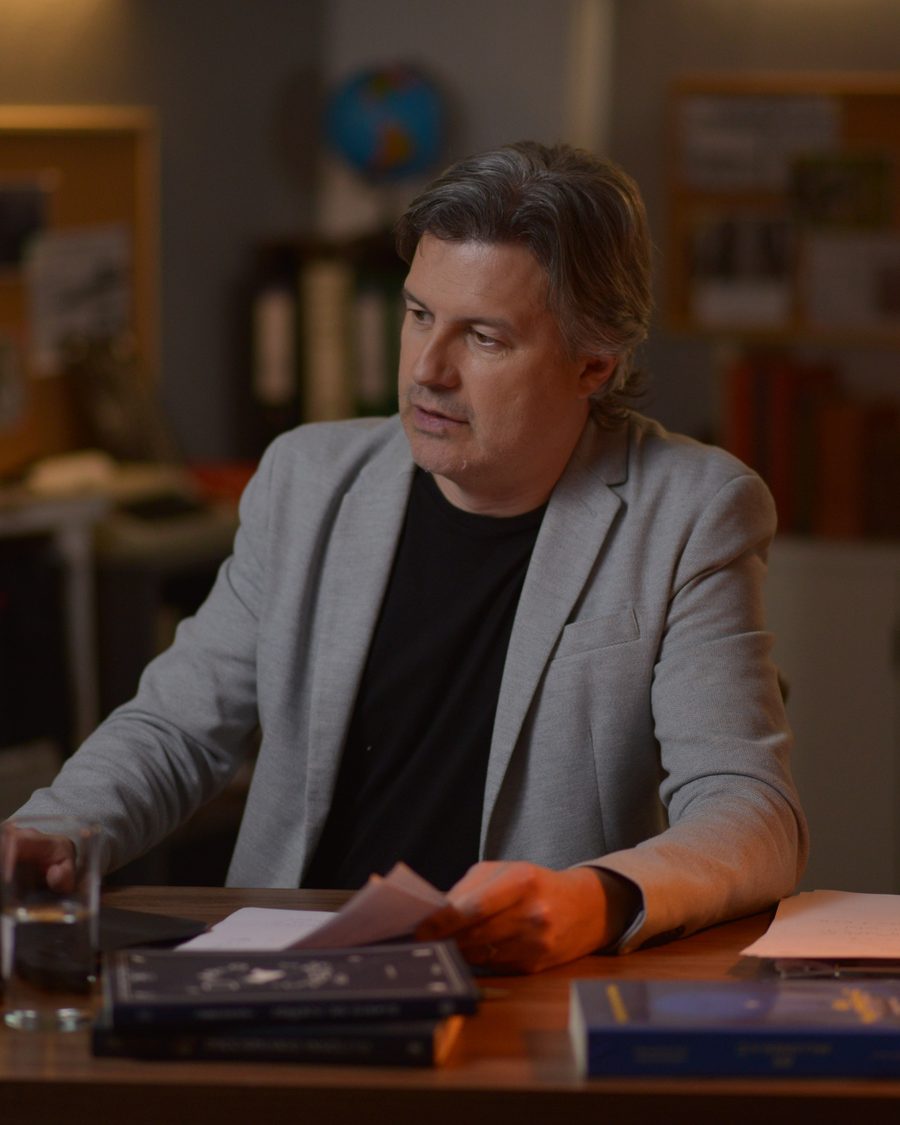 Henri Gelencser en su escritorio, revisando documentos a la luz de una lámpara